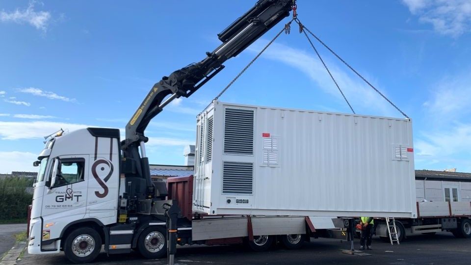 camion grue levant un data center en conteneur / a crane lorry lifting a containerised data centre