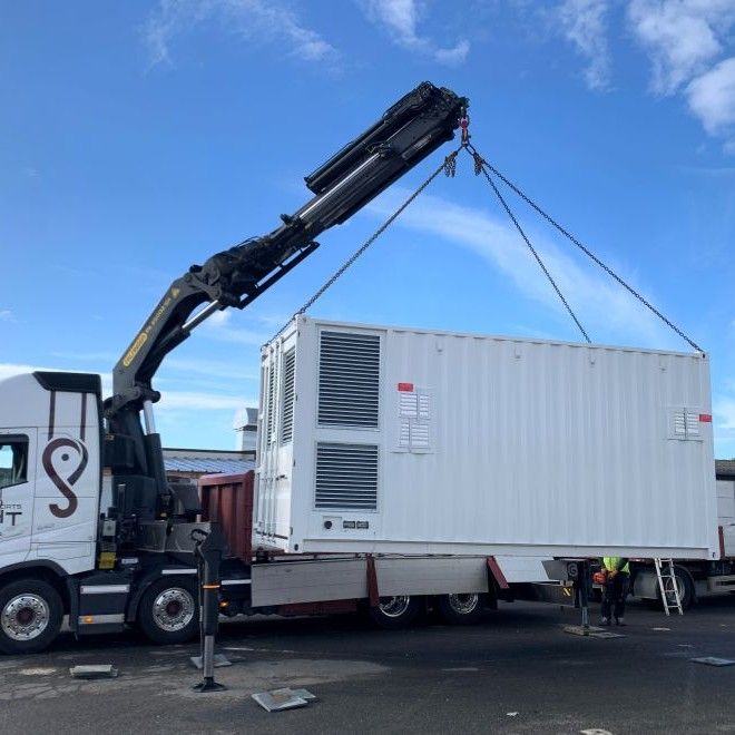 camion grue levant un data center en conteneur / a crane lorry lifting a containerised data centre